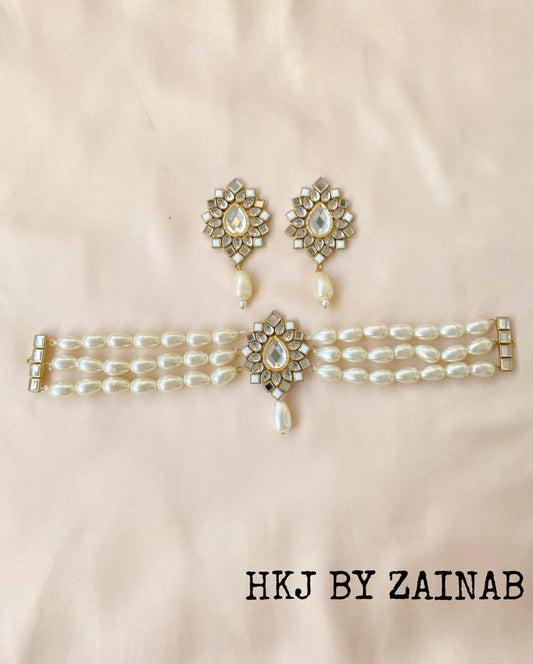 Pearl choker and earrings set with floral designs on a beige background, branded 'HKJ by Zainab'.