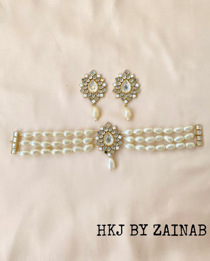 Pearl choker and earrings set with floral designs on a beige background, branded 'HKJ by Zainab'.