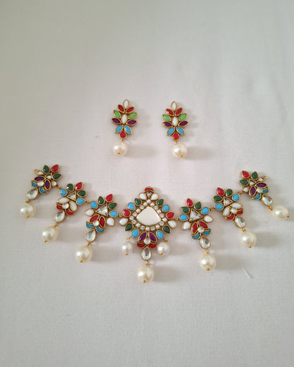 Set of decorative earrings with pearls and gemstones on a light gray background