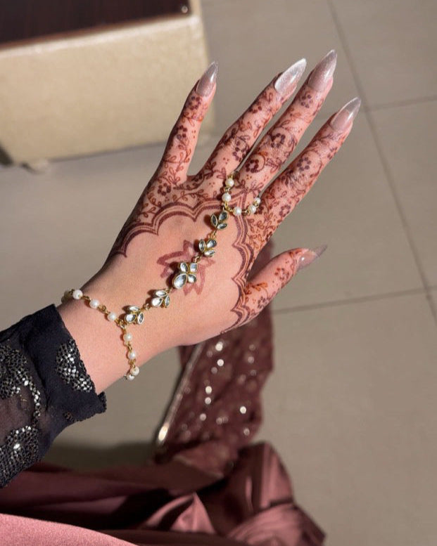 Hand with intricate henna design on a blurred background